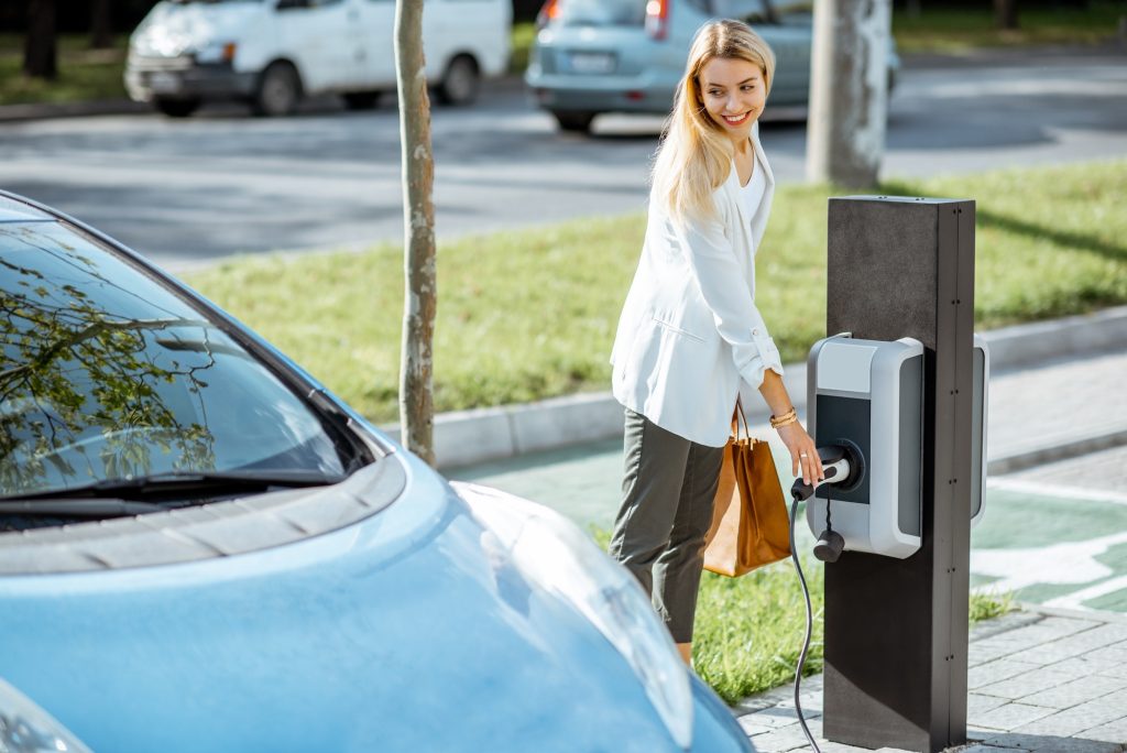 Woman charging electric car